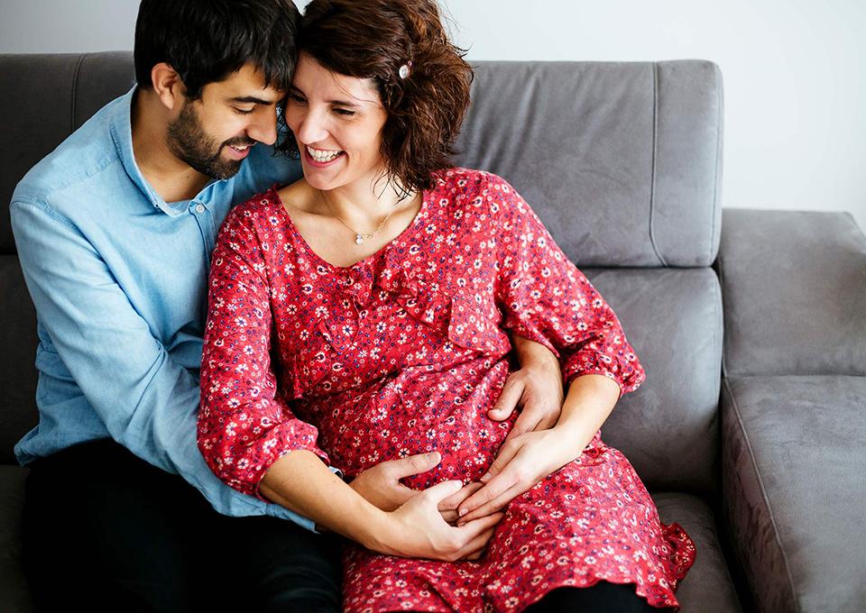 怀孕的夫妇坐在沙发上