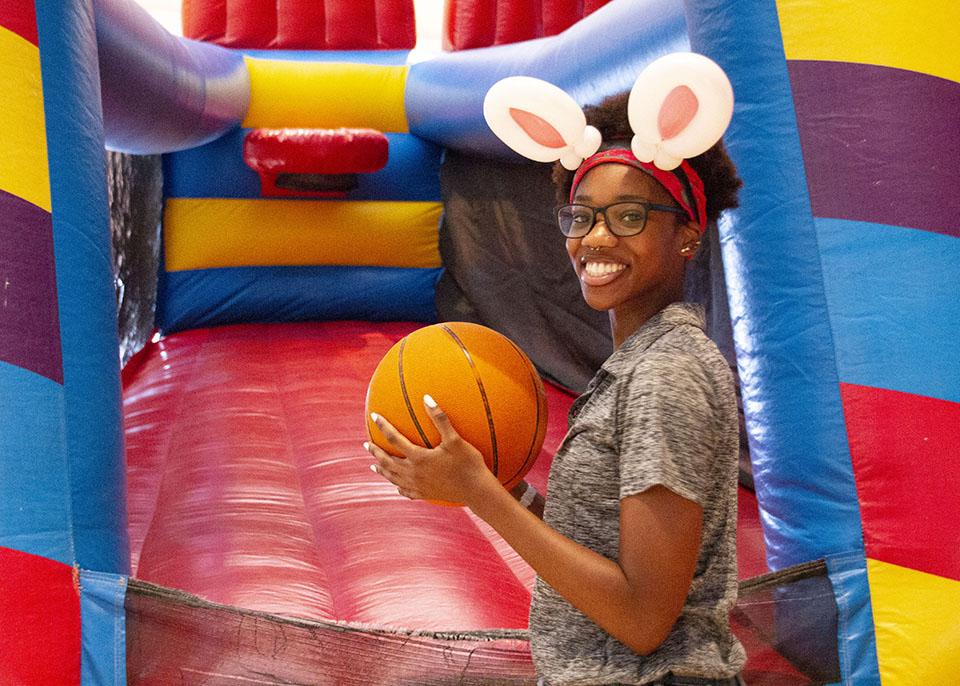 女学生戴着兔耳发带，拿着篮球